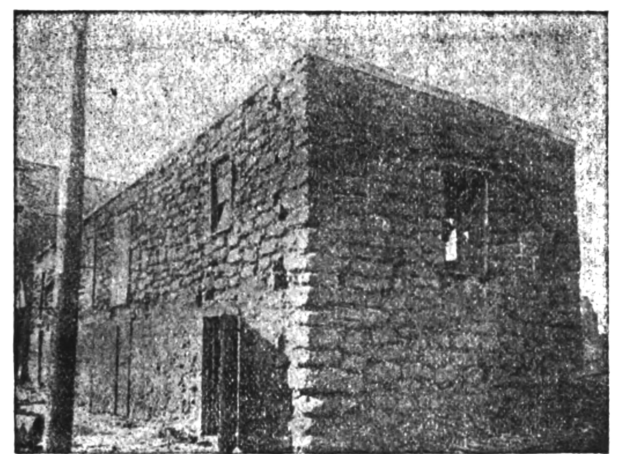 Grainy black-and-white halftone photograph of the two-story Old Stone Fort in Nacogdoches, a rough stone building with small square openings.